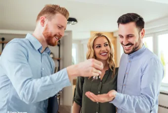 Un homme donne les clés à un couple