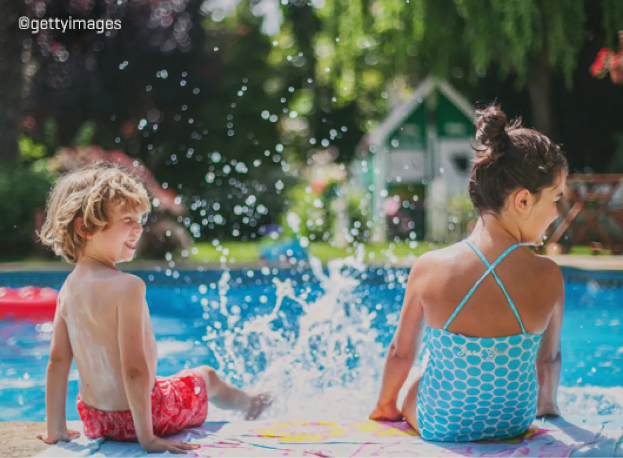 Twee kinderen met voeten aan het plonzen in zwembad